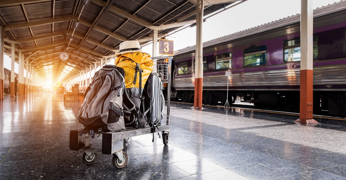 A traveler's baggage cart on an urban railway station platform at sunrise.