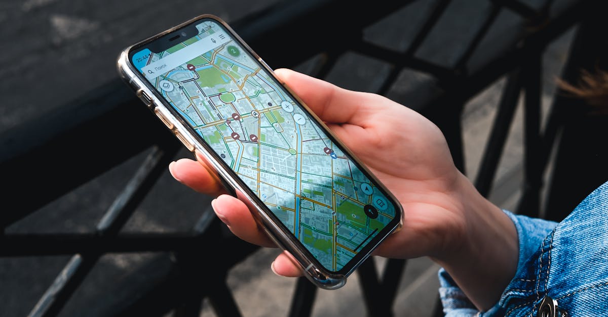 An outdoor close-up of a hand holding a smartphone displaying a map application.