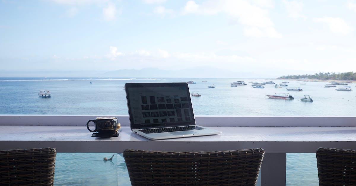 Serene beach view workspace in Bali with a laptop and coffee mug. Perfect for remote work inspiration.